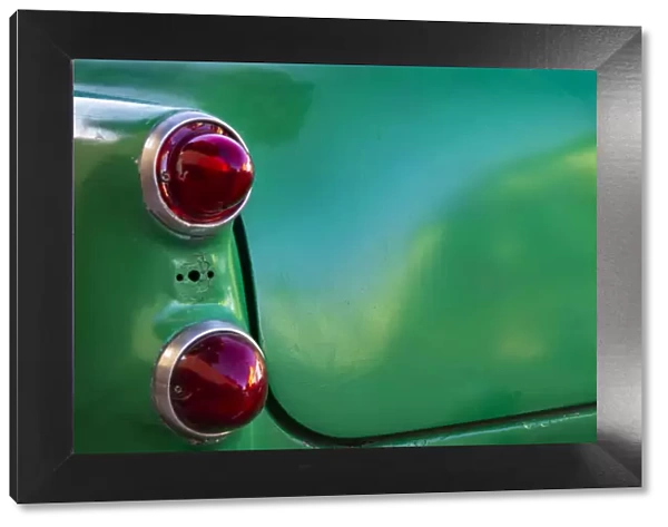 Detail of two red tail lights on classic green car in Trinidad, Cuba