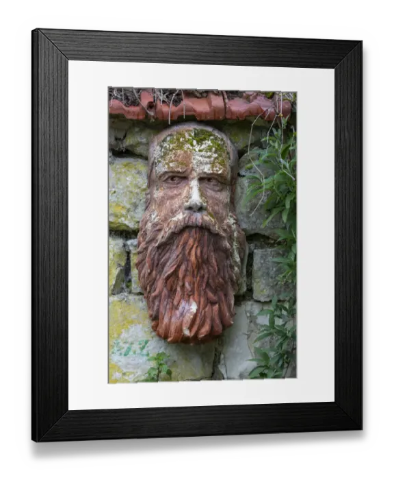 Framed Print : France, Giverny. Stone face hanging on a stone wall. Credit as Framed Print : France, Giverny. Stone face hanging on a stone wall. Credit as