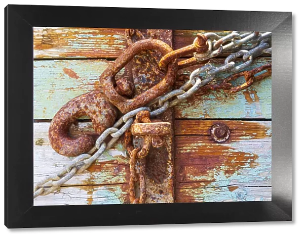 Rusty lock and chain on light blue wood