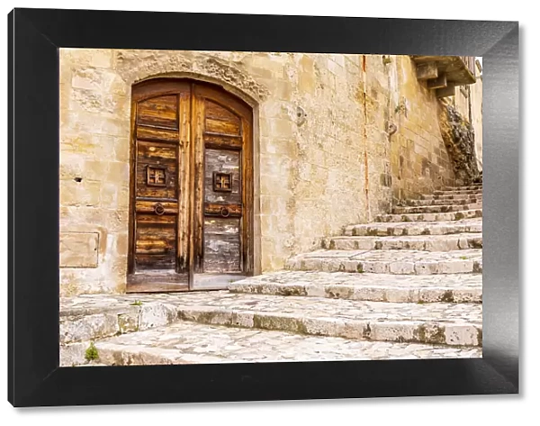 Italy, Basilicata, Province of Matera, Matera. Old wooden door in a stone wall above