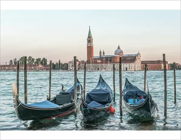 Italy, Venice. Gondolas on the waterfront with San Giorgio Maggiore Church in the