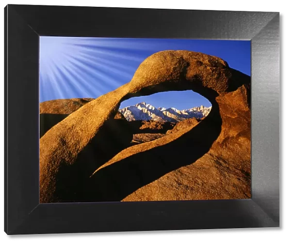 USA, California, Alabama Hills. Sun rays and granite arch that frames Lone Pine Peak