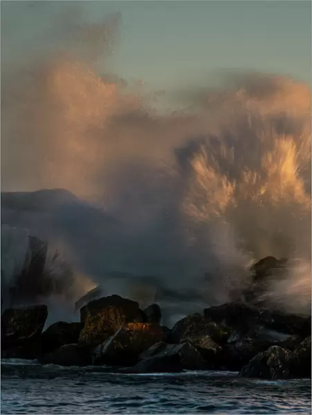 USA, Minnesota, Lake Superior. Lake waves breaking on rocks at sunset