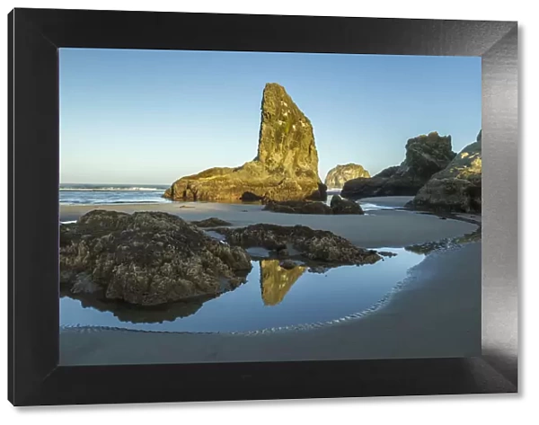 USA, Oregon, Bandon Beach. Rock formations and reflection in beach water