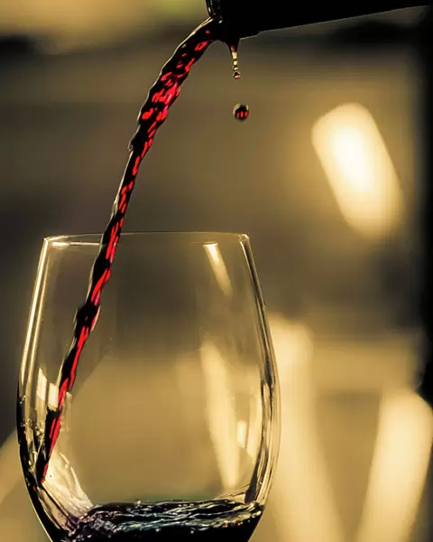 One drop shows as red wine is poured into glass