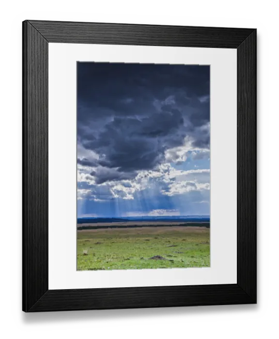 Framed Print : Clouds with sun rays streaming down on Masai Mara in Kenya, Africa Framed Print : Clouds with sun rays streaming down on Masai Mara in Kenya, Africa