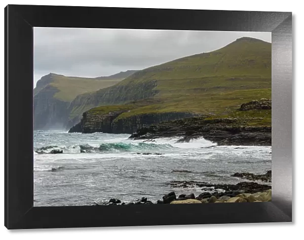Europe, Faroe Islands. View of the northern coast pounded by storm surf from the village