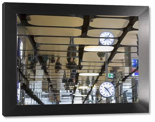 Europe, Netherlands, Amsterdam. Commuters reflected in ceiling of central train station