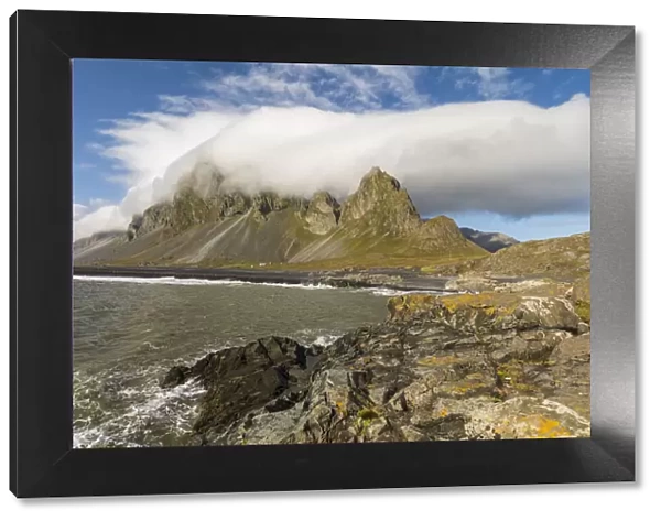 Europe, Iceland. Clouds drape the mountains of Eystrahorn on the south coast