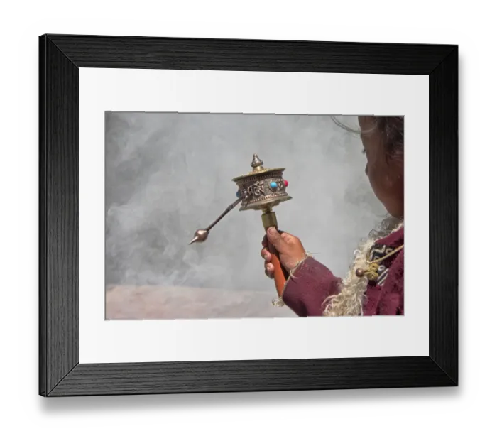 Framed Print : Little Tibetan girl praying with prayer wheel and smoke from incense in Drepung Monastery