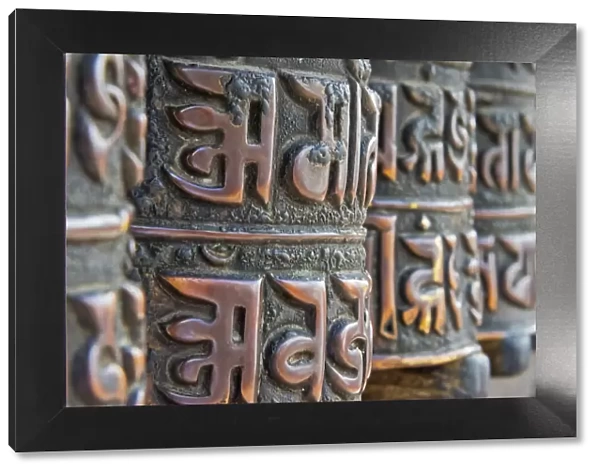 Bronze prayer wheels carved with Buddhist scripture, Swayambhunath, Kathmandu, Nepal