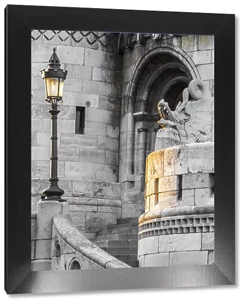Hungary, Budapest. Light hitting lamppost, staircase, and dragon statue on Fisherman