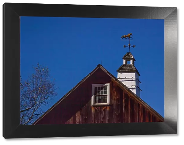 USA, New England, Vermont weather vane on top of wooden barn topped with horse