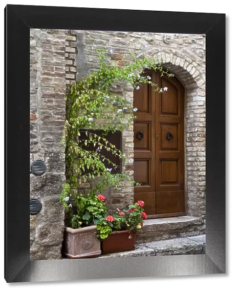 Italy, Tuscany, San Gimignano. Homes decorated with flower pots along the streets of San Gimignano