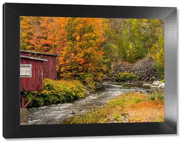 USA, Vermont, Stowe, red mill on Little River as it flows south of Stowe to Winooski River, fall foliage