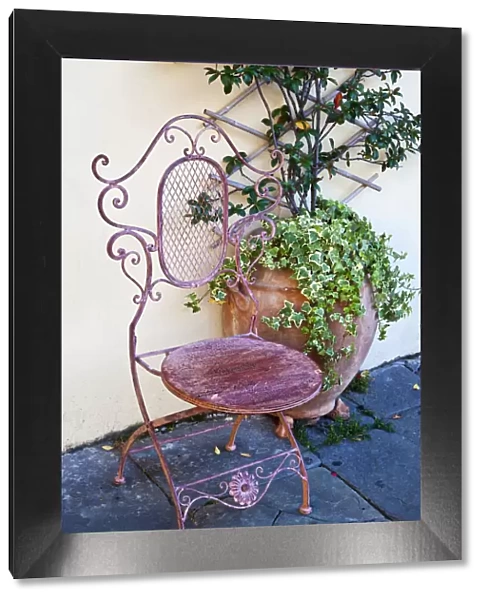 Italy, Tuscany, Lucca. Decorative chair and potted plant outside a shop in the Piazza dell Anfiteatro Romano
