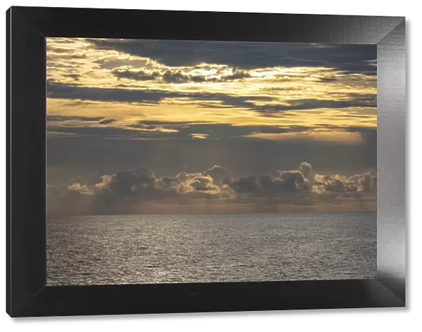 Dramatic skies, rain, sunbeams, sunset colors kiss the horizon of the Gulf of Mexico, Florida