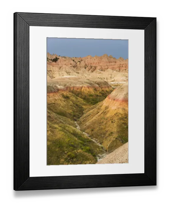 Framed Print : The grassy valley with dry creek is fed by the run off of the hoodoos lining the side