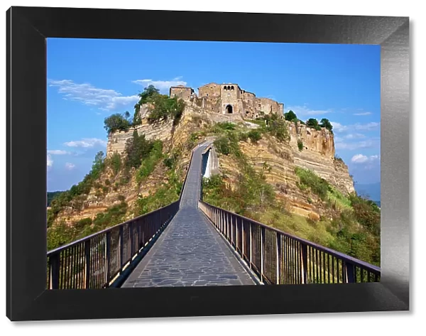 Italy, Tuscany. Evening view of Civita di Bagnoregio and the long bridge leading to town
