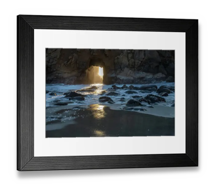 Framed Print : Sun shines through a tunnel in a sea cliff in the Big Sur area