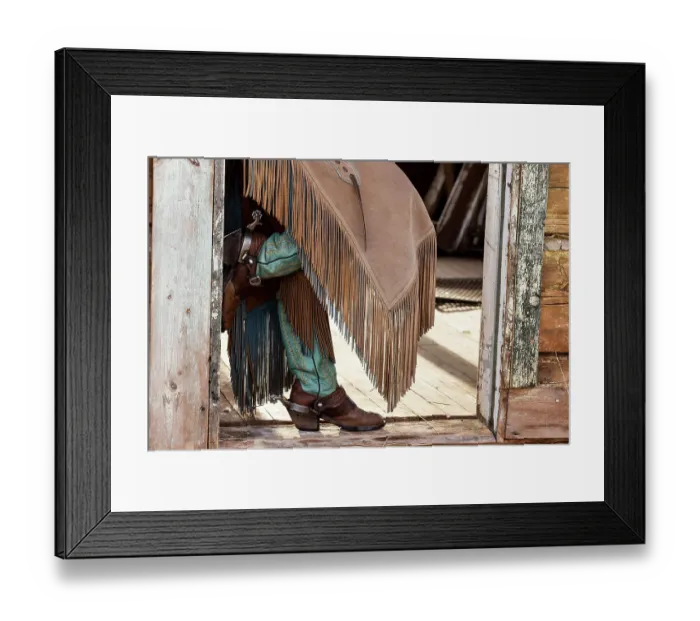 Framed Print : USA, Shell, Wyoming. Hideout Ranch cowgirl standing in doorway with cowboy boots and chaps. (PR, MR) Framed Print : USA, Shell, Wyoming. Hideout Ranch cowgirl standing in doorway with cowboy boots and chaps. (PR, MR)