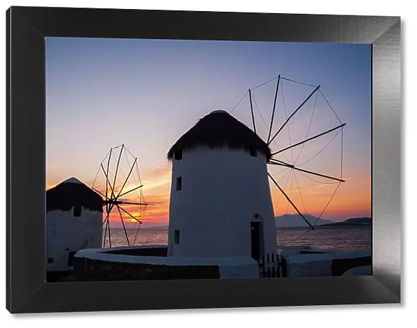 Traditional-style windmills on the coast at sunset. Chora, Mykonos Island, Cyclades Islands, Greece