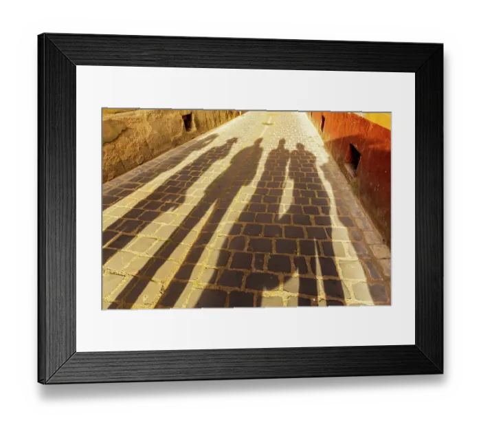 Framed Print : Romania, Brasov. Shadowed figures in silhouette on street cobblestone Framed Print : Romania, Brasov. Shadowed figures in silhouette on street cobblestone