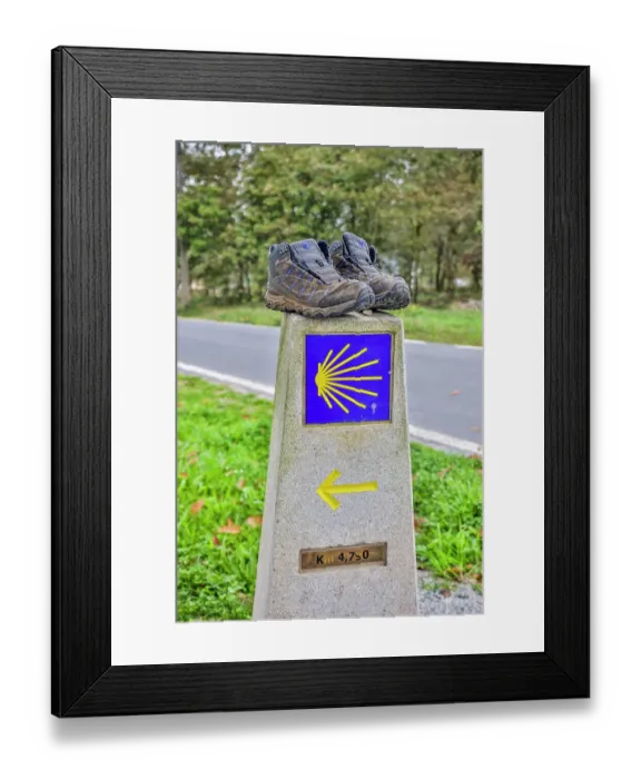 Framed Print : Spain, Galicia. Distance marker on the Camino de Santiago (Way of St. James) with a pair of well worn shoes. (Editorial Use Only)