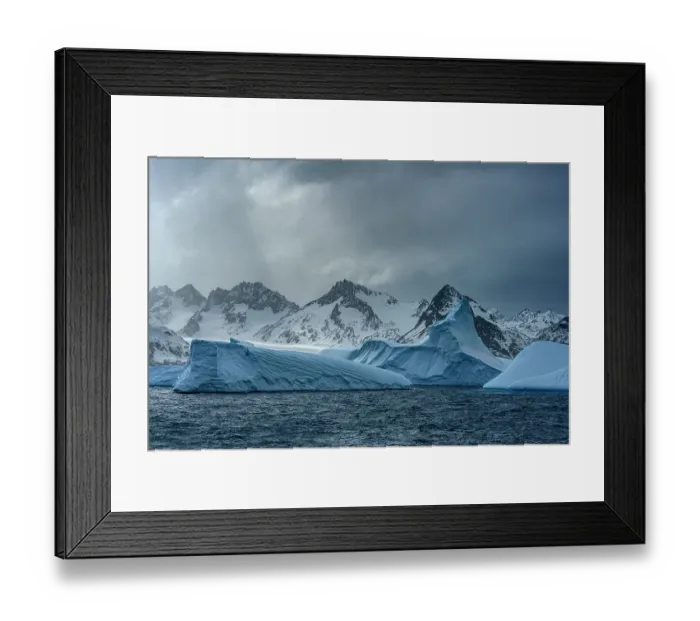 Framed Print : South Georgia Island. Sculpted blue icebergs floating in the Atlantic and mountain scenery