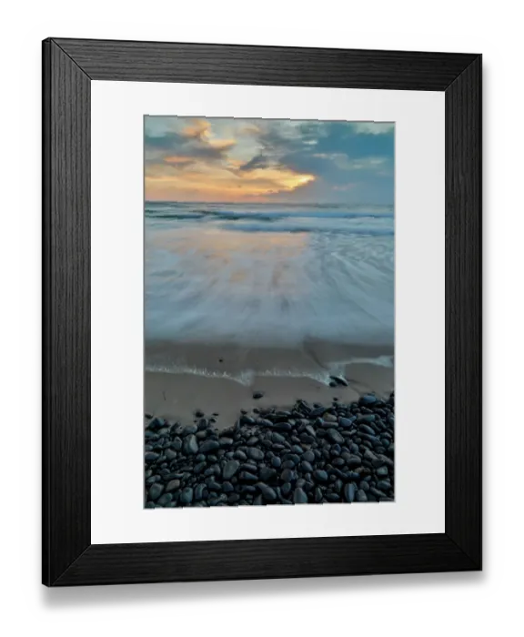 Framed Print : USA, Oregon, Arch Cape. Pacific coastline last evening light reflected in the sandy beach at low tide with foreground of shiny round black rocks