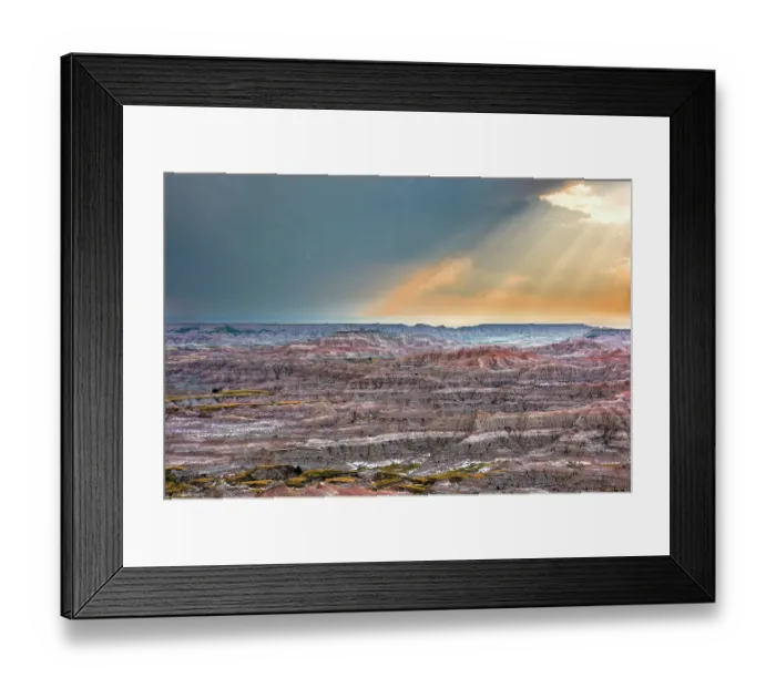 Framed Print : Sunrays over striated, dramatic, badland hills