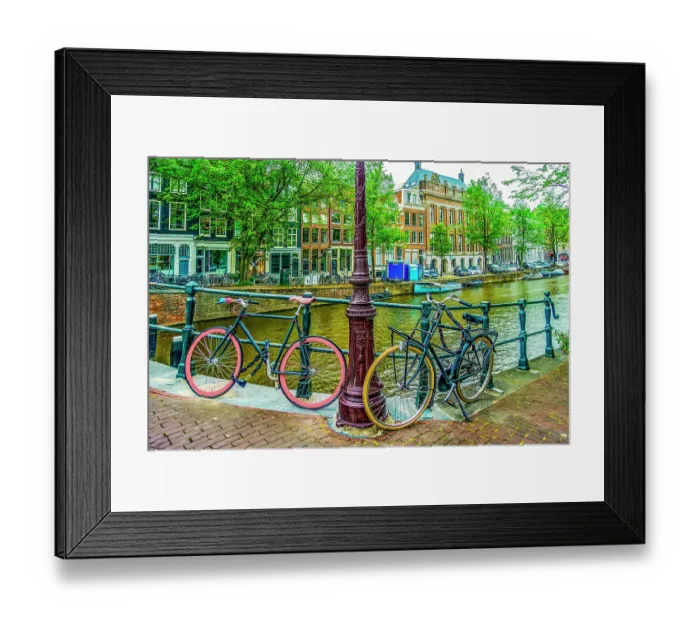 Framed Print : Amsterdam, Netherlands. Wide angle landscape view of boat lined canal, historic canal tall houses and bicycles
