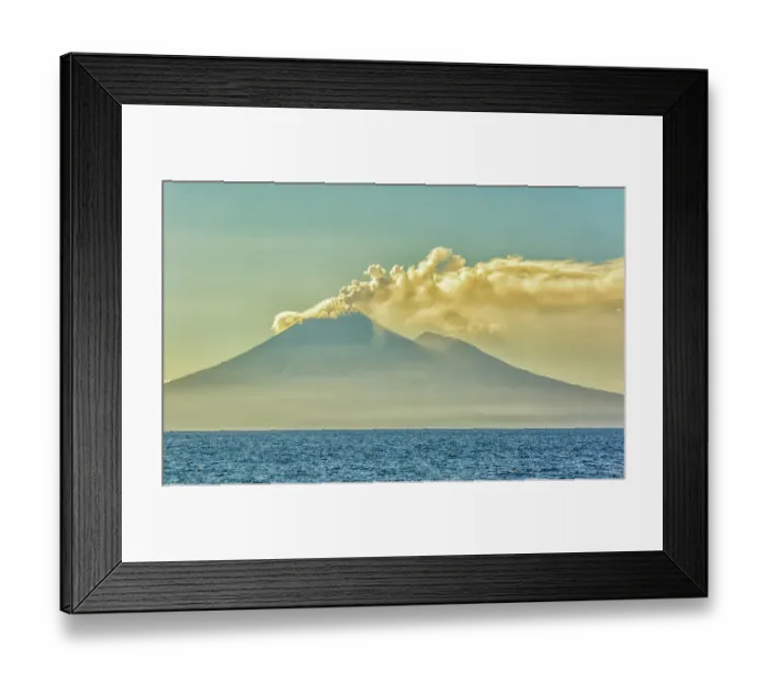 Framed Print : Active Volcano, Coral Sea, Papua New Guinea. Landscape view across the ocean water of an active volcano puffing smoke at sunrise Framed Print : Active Volcano, Coral Sea, Papua New Guinea. Landscape view across the ocean water of an active volcano puffing smoke at sunrise