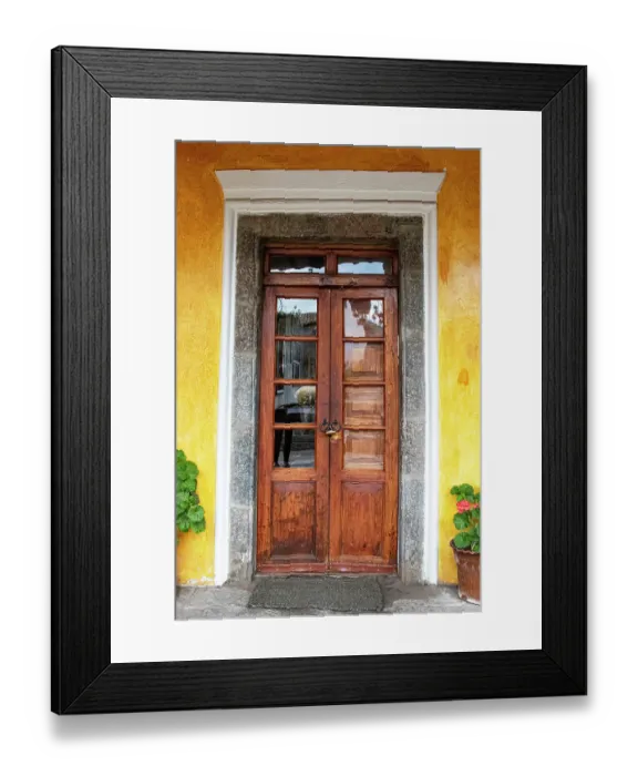Framed Print : Old wooden doorway flanked by two geranium plants at Hacienda San Augustin de Callo in the Cotopaxi region of Ecuador. (Editorial Use Only)