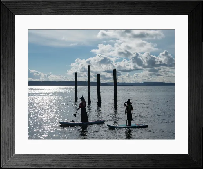 Framed Print : Port Townsend, Washington State. Silhouettes of two women dressed as witches on paddleboards
