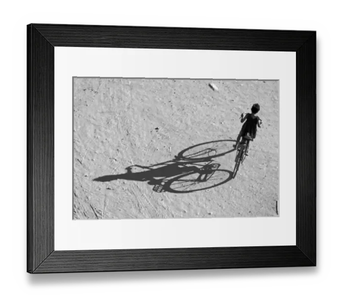 Framed Print : Myamar, Bagan, Young boy riding a huge bike and his long shadow on a sandy field Framed Print : Myamar, Bagan, Young boy riding a huge bike and his long shadow on a sandy field
