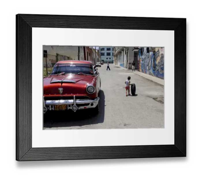 Framed Print : African Hamel district, Havana, Cuba, UNESCO World Heritage City. Child playing with old tire