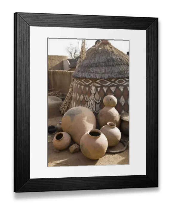 Framed Print : Africa, West Africa, Ghana, Sirigu. Handcrafted pottery leaning against traditional