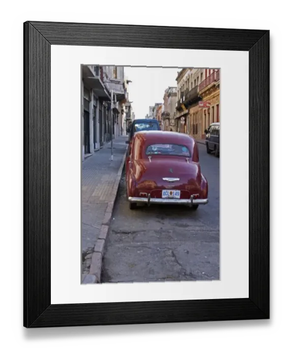 Framed Print : A classic old red Peugeot car parked on a street corner, probably from the 1950s