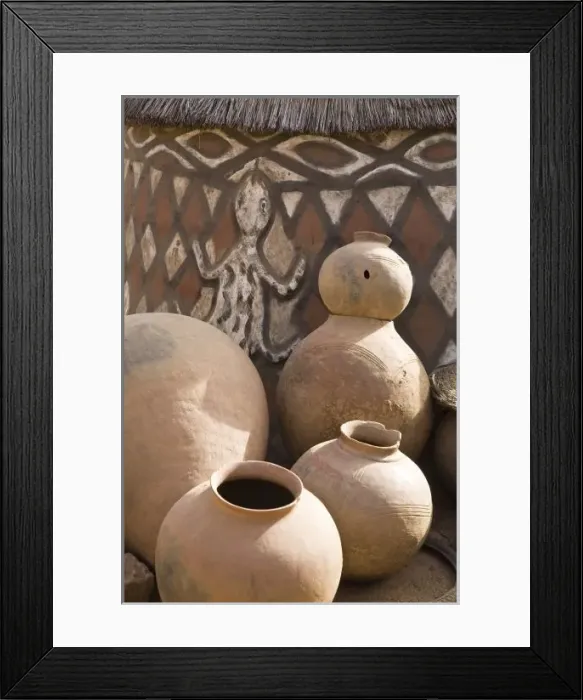 Framed Print : Africa, West Africa, Ghana, Sirigu. Handcrafted pottery leaning against traditional