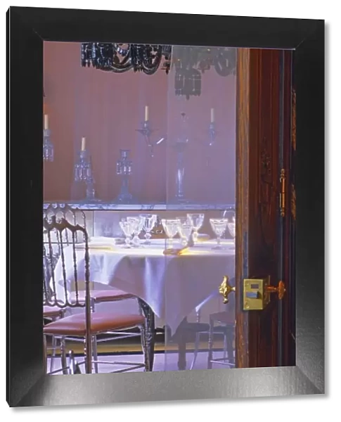 The private dining room with the black crystal chandelier seen through a door at
