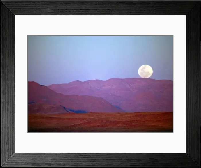 Framed Print : Africa, Namibia, Sossusvlei. A full moon rests on the crest of foothills in the NamibRand