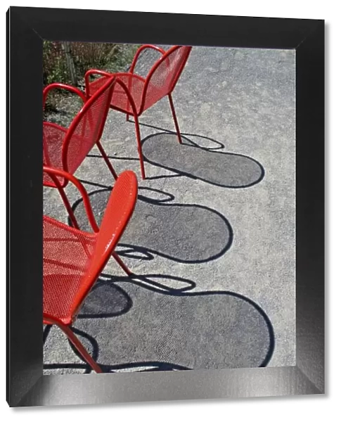 Red wire chairs shadows on concrete