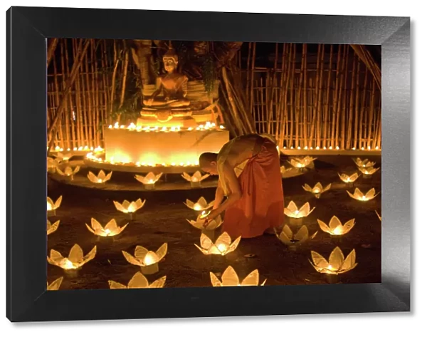 Monks lighting khom loy candles and lanterns for Loi Krathong festival