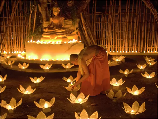Monks lighting khom loy candles and lanterns for Loi Krathong festival