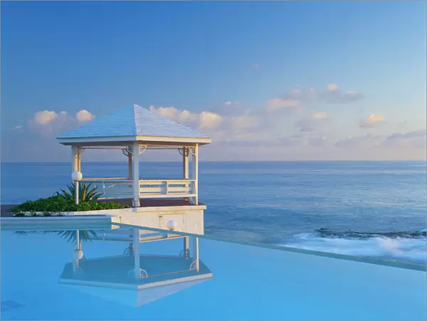 Bahamas, Long Island, Gazebo reflecting on pool with sea in background