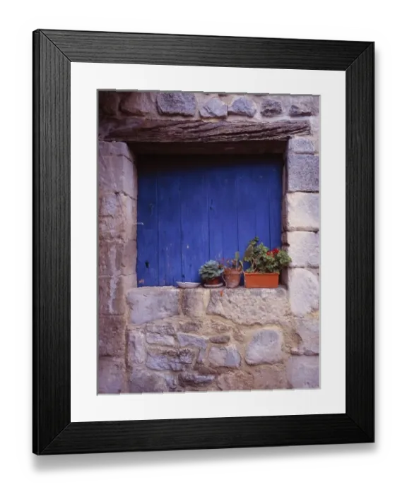 Framed Print : Europe, France, Cereste. A blue door adds color to this grey stone wall in Cereste