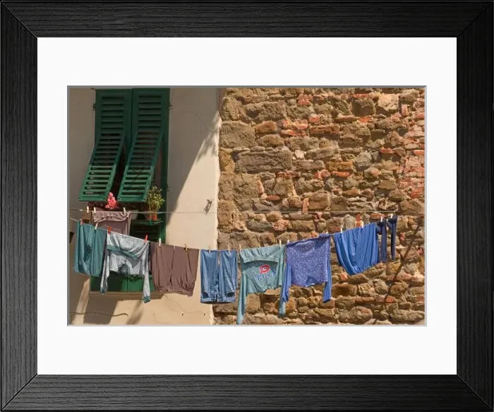 Framed Print : A line of clothes dries between buildings near an open air market in Figline, Tusacny, Italy Framed Print : A line of clothes dries between buildings near an open air market in Figline, Tusacny, Italy