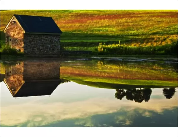 USA, Delaware, Wilmington. Stone barn on edge of lake in Winterthur Gardens