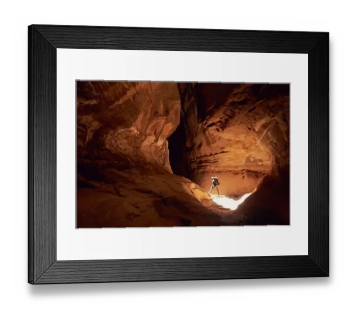 Framed Print : Canyoneer illuminated in the depths of a narrow canyon in the Dirty Devil Canyon